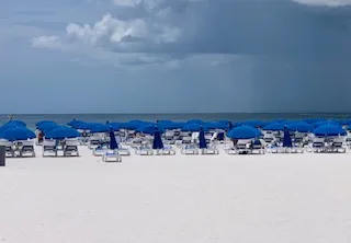 Blue beach umbrellas on the white sand of Marco Island